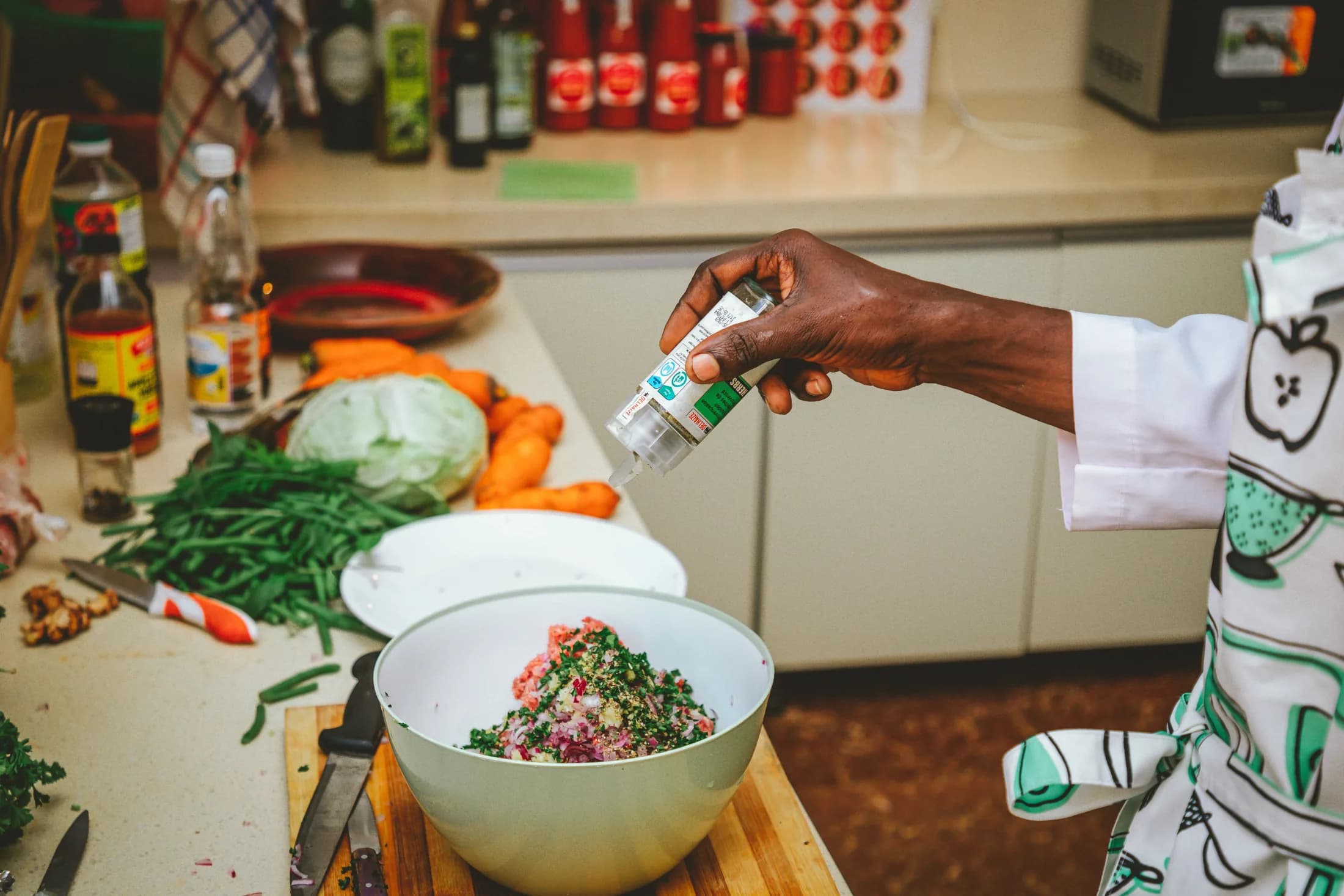 Fresh vegetables being seasoned in a kitchen
