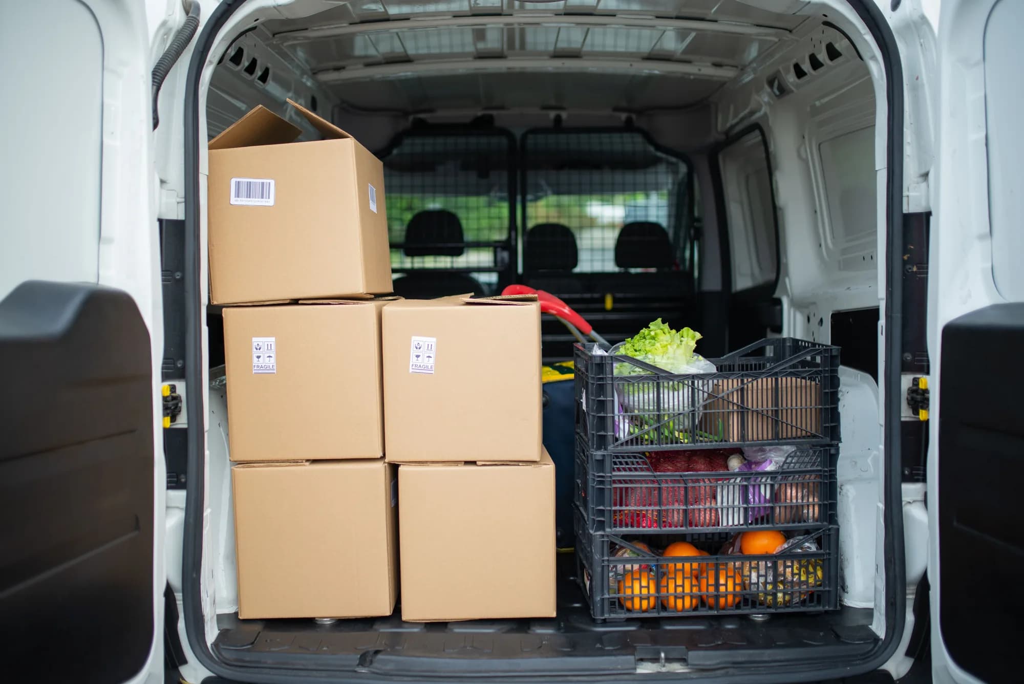 Packed produce and delivery boxes loaded into a van